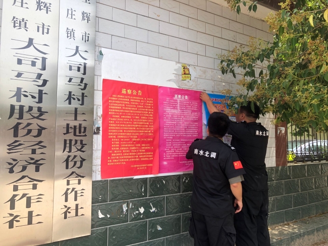 在社区宣传栏贴宣传海报