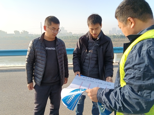 郭培峰、罗克厅在与维护单位负责人讨论自动抽排水系统