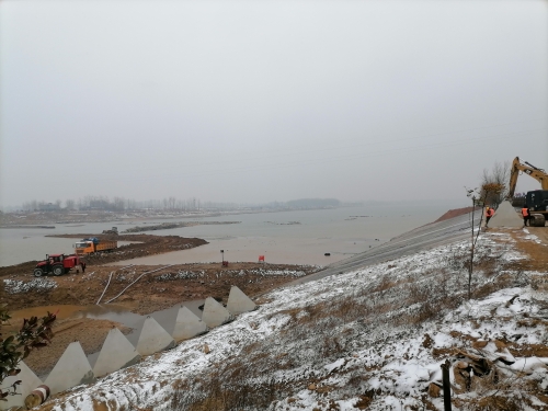 图为风雪下的白河倒虹吸防洪加固项目右岸围堰施工现场